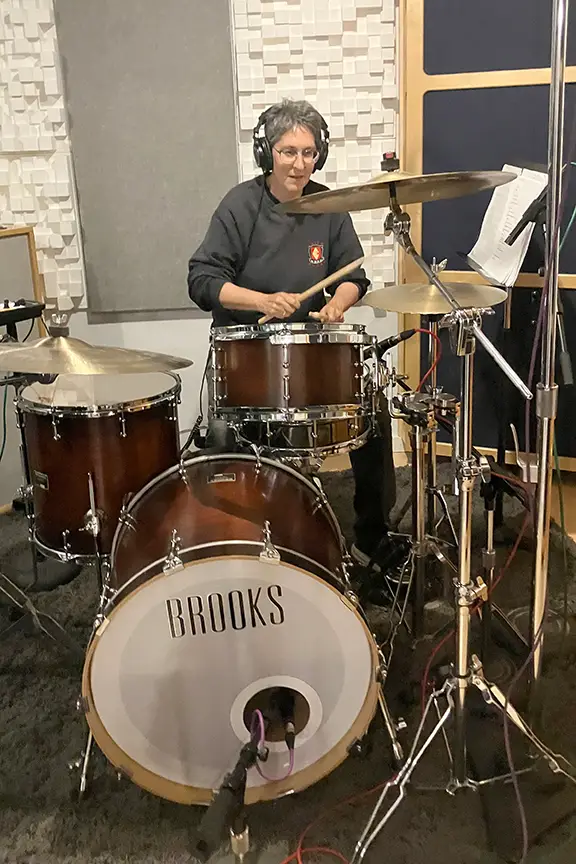 Lynne drumming in a studio